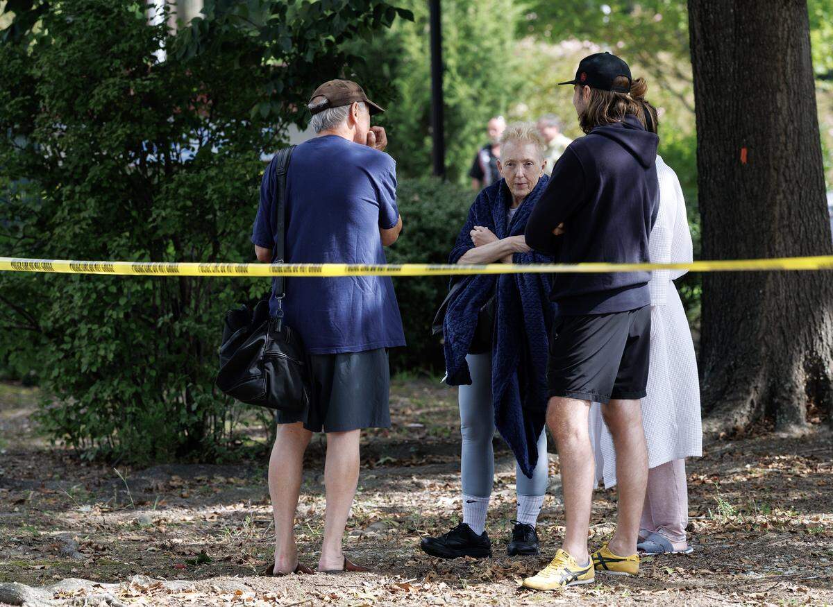 Kimberly Heller, center, talks with other Siena Hotel guests hours after they evacuated the building due to an early morning fire on Friday, Aug. 22, 2025, in Chapel Hill, N.C. 