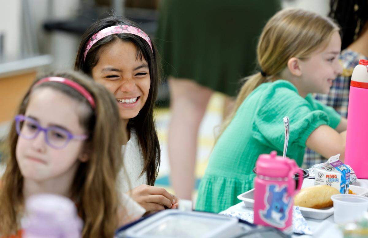 Combs Elementary School fourth grader Isbella Santos eats lunch during the Silver Tray lunch at Combs Elementary School in Raleigh, N.C., Thursday, May 16, 2024. At the Silver Tray Luncheon there is fancy silverware, cafeteria tables have tablecloths and centerpieces as the Enloe High School orchestra plays music to provide a fine dining experience. The dining experience was the culmination of a year-long effort to teach Combs’ students about the value of social etiquette and good manners.