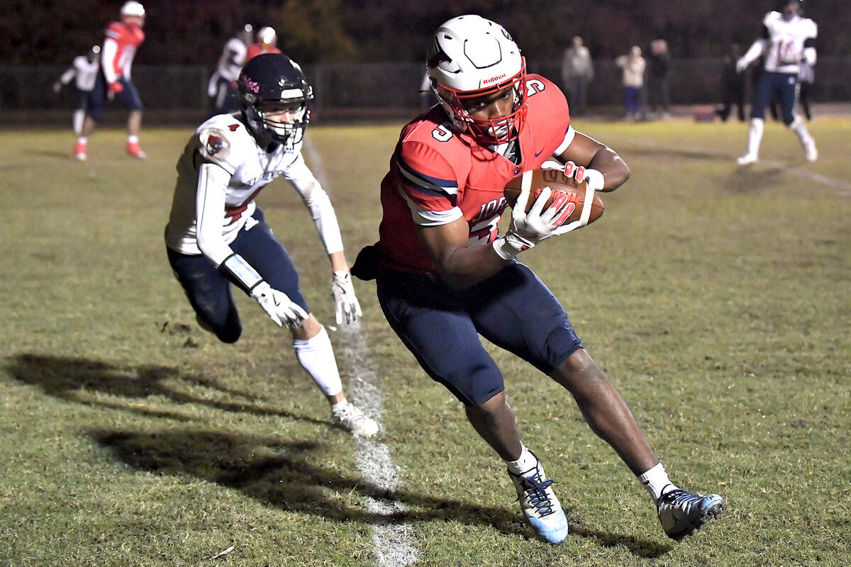 Jordan wide receiver Joe Griffin (5) makes the catch and runs the short yardage for the touchdown against Apex Friendship’s Trevor Galvanek (4) during the second half. The Apex Friendship Patriots and the Durham Jordan Falcons met in the second round of the NCHSAA 4A playoffs in Durham, N.C. on November 22, 2024.