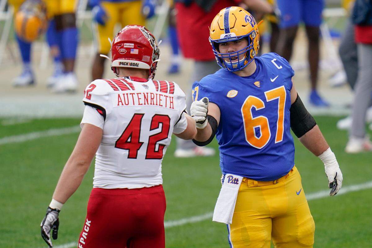 North Carolina State tight end Dylan Autenrieth (42) greets Pittsburgh Panthers offensive lineman Jimmy Morrissey (67) before the coin toss before their NCAA college football game, Saturday, Oct. 3, 2020, in Pittsburgh.
