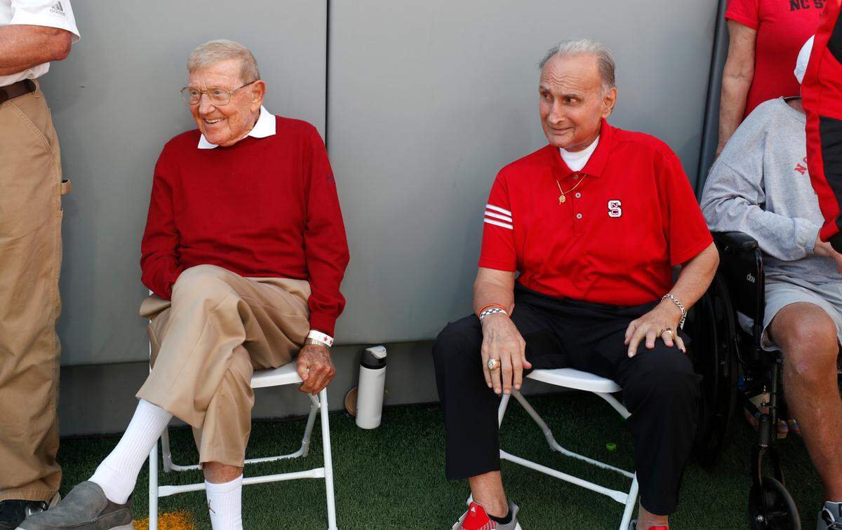 Former N.C. State coach Lou Holtz and former N.C. State linebacker and coach Chuck Amato sit on the field before members of the 1973 ACC championship team was introduced during N.C. State’s game against Marshall at Carter-Finley Stadium in Raleigh, N.C., Saturday, Oct. 7, 2023.