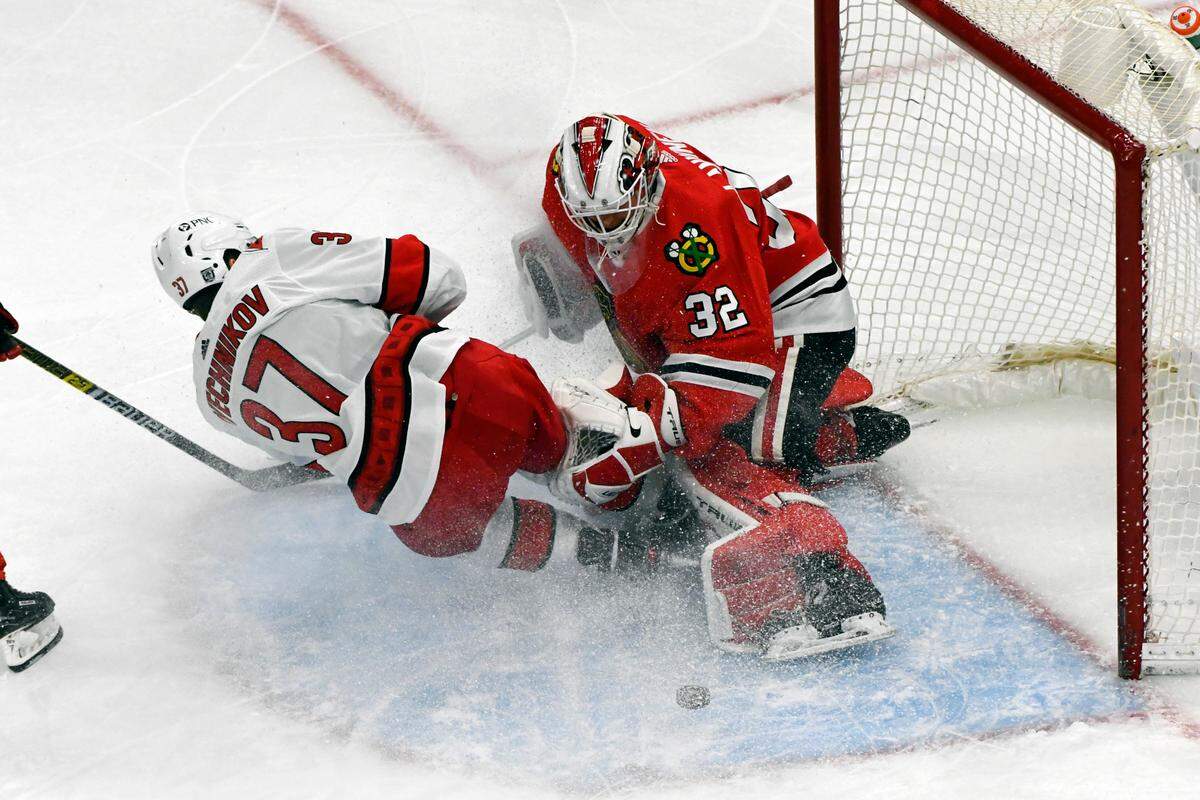 Carolina Hurricanes right wing Andrei Svechnikov (37) slides into Chicago Blackhawks goaltender Kevin Lankinen (32) during the first period of an NHL hockey, Tuesday, Feb. 2, 2021, in Chicago. (AP Photo/Matt Marton)