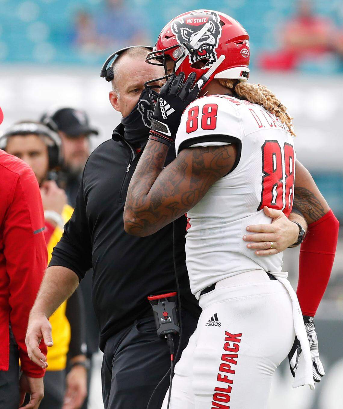N.C. State head coach Dave Doeren talks with wide receiver Devin Carter (88) during the second half of Kentucky’s 23-21 victory over N.C. State in the Gator Bowl at TIAA Bank Field in Jacksonville, Fla., Saturday, January 2, 2021.