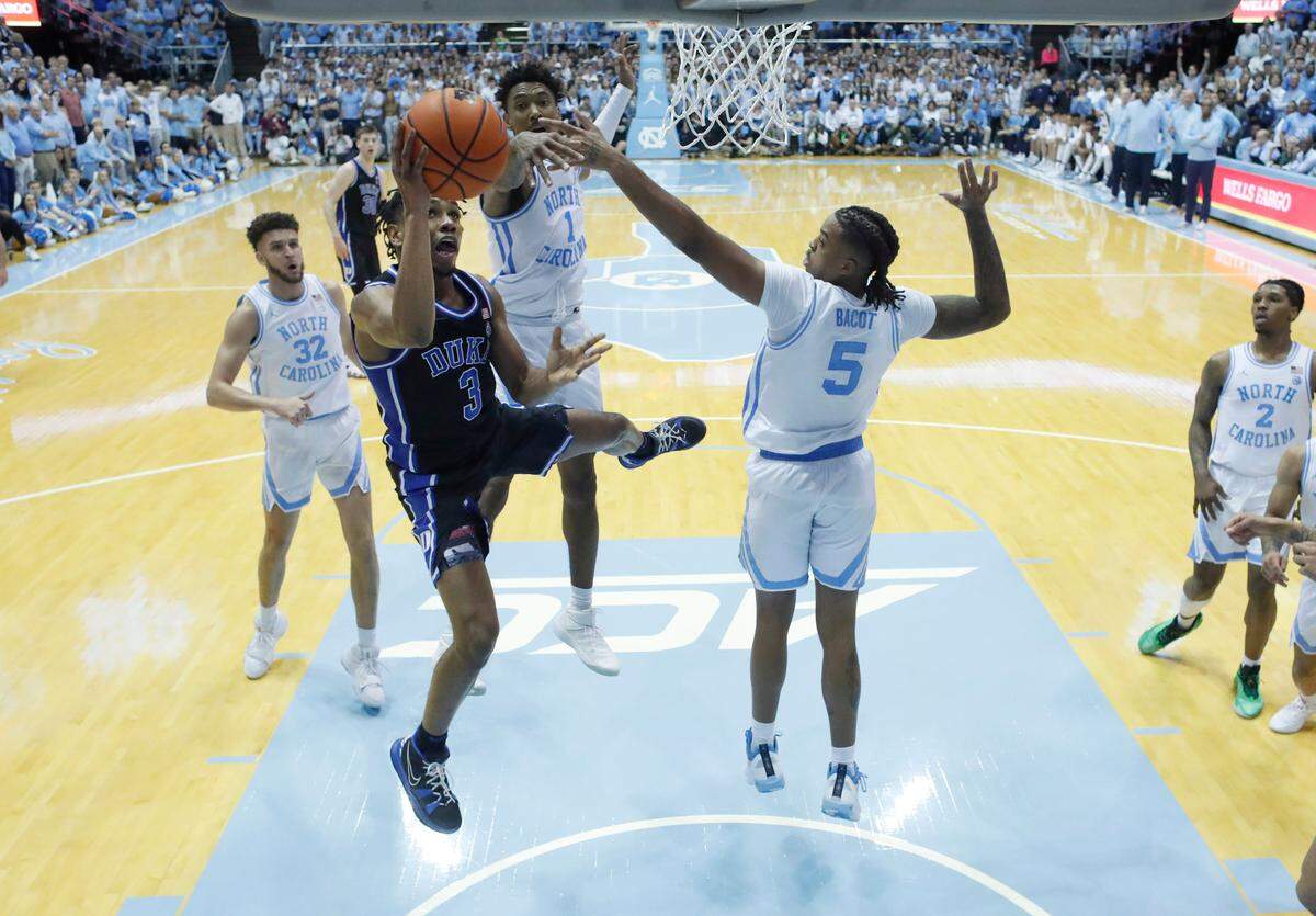 Duke’s Jeremy Roach (3) drives between North Carolina’s Armando Bacot (5) and Leaky Black (1) to make the basket to put the Blue Devils up 60-57 with 48 seconds left in the game during Duke’s 62-57 victory over UNC at the Smith Center in Chapel Hill, N.C., Saturday, March 4, 2023.