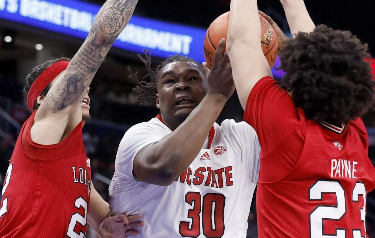 N.C. State’s DJ Burns Jr. (30) works between Louisville’s Tre White (22) and Zan Payne (23) during the second half of N.C. State’s 94-85 victory over Louisville in the first round of the 2024 ACC Men’s Basketball Tournament at Capital One Arena in Washington, D.C., Tuesday, March 12, 2024.