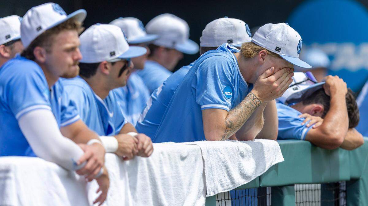 North Carolina pitcher Cameron Padgett (15) covers his face in the Tar Heels’ dugout following their 4-3 loss to Arizona in the NCAA Super Regional final on Sunday, June 8, 2025 at Boshamer Stadium in Chapel Hill, N.C.