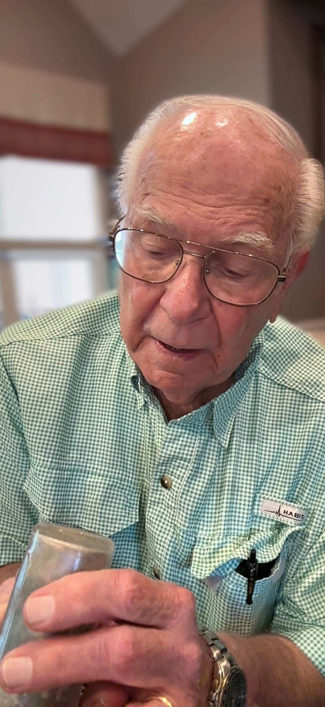 Ted Haviland shows the medicine bottle taken from the merchant ship sunk by the Nazis, killing his father.