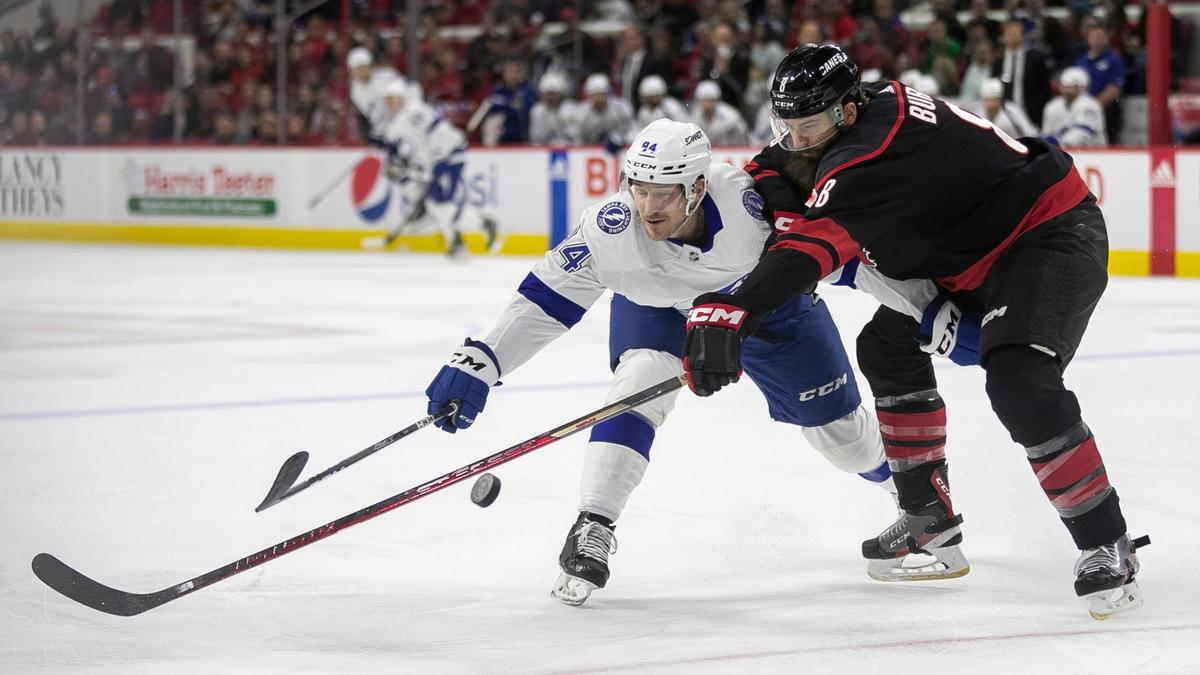Carolina Hurricanes’ Brent Burns (8) and Tampa’s Tanner Jeannot (84) battle for the puck during the first period on Tuesday, March 28, 2023 at PNC Arena in Raleigh, N.C.