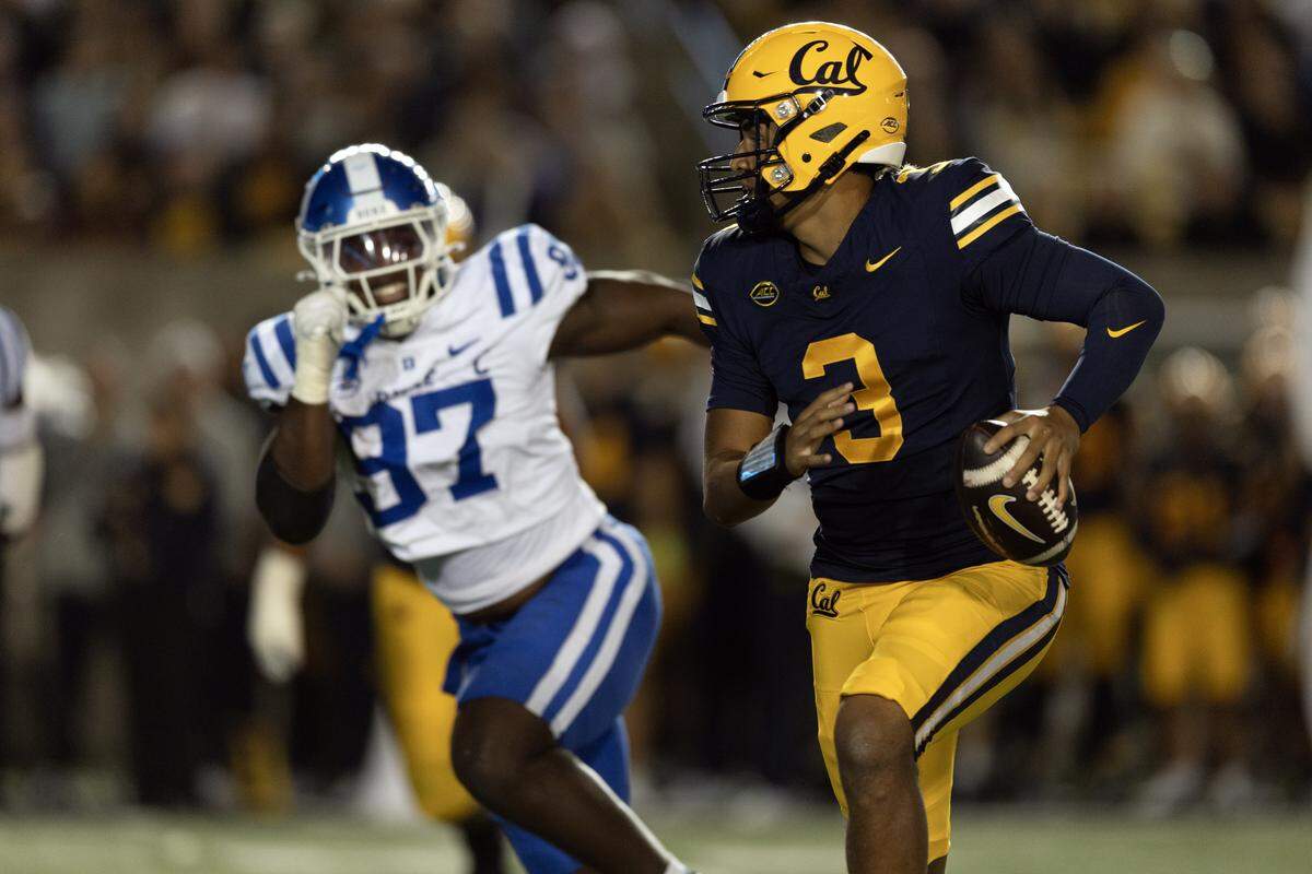 California Golden Bears quarterback Jaron-Keawe Sagapolutele (3) scrambles away from pressure by Duke Blue Devils defensive end Wesley Williams (97) during the second quarter at California Memorial Stadium. 