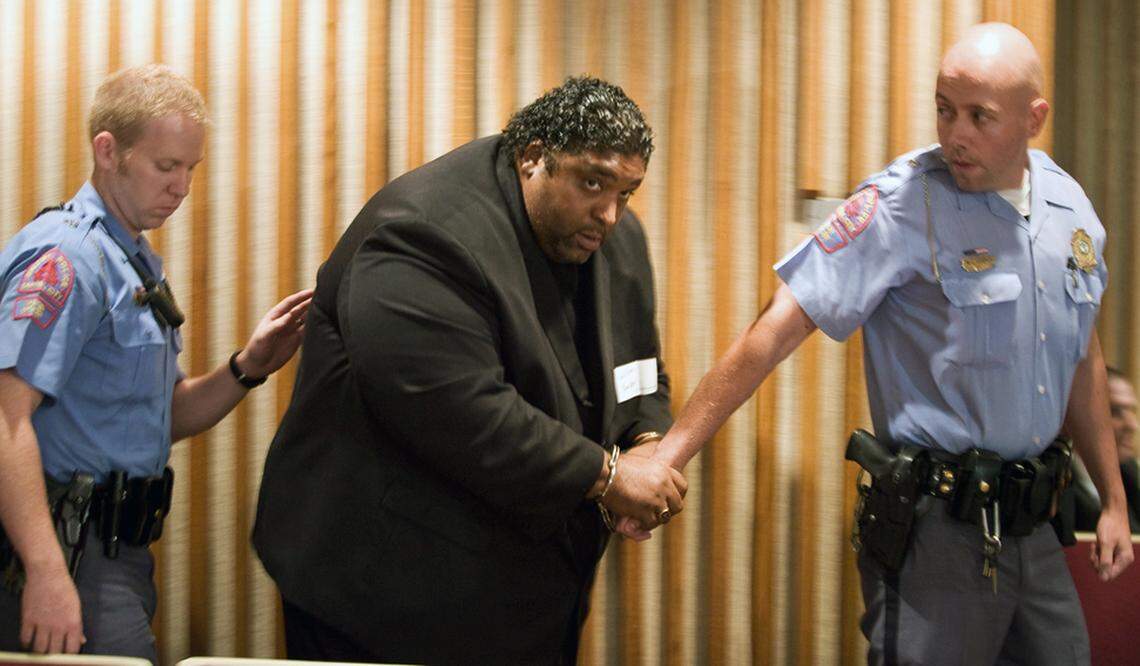 The Rev. William Barber, N.C. chapter president for the NAACP, is escorted from the Wake County Schools board room in handcuffs after he was arrested for staging a sit-in with three other activists during a recess of the board’s meeting on June 13, 2010.