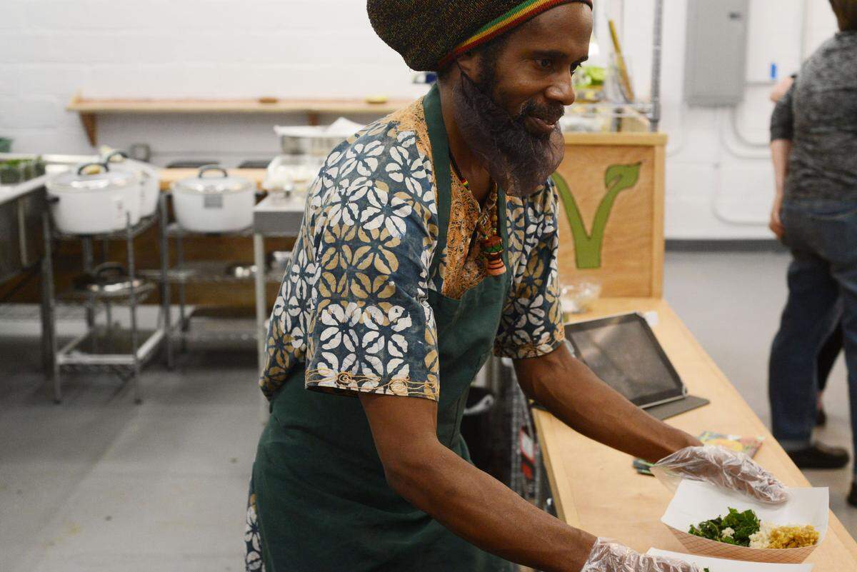 Kale is a popular vegetable at farmer’s market stands in March. Pictured, Yah-i Amen of Chapel Hill’s Vegan Flava Cafe serves curried lentils with coconut rice and kale.