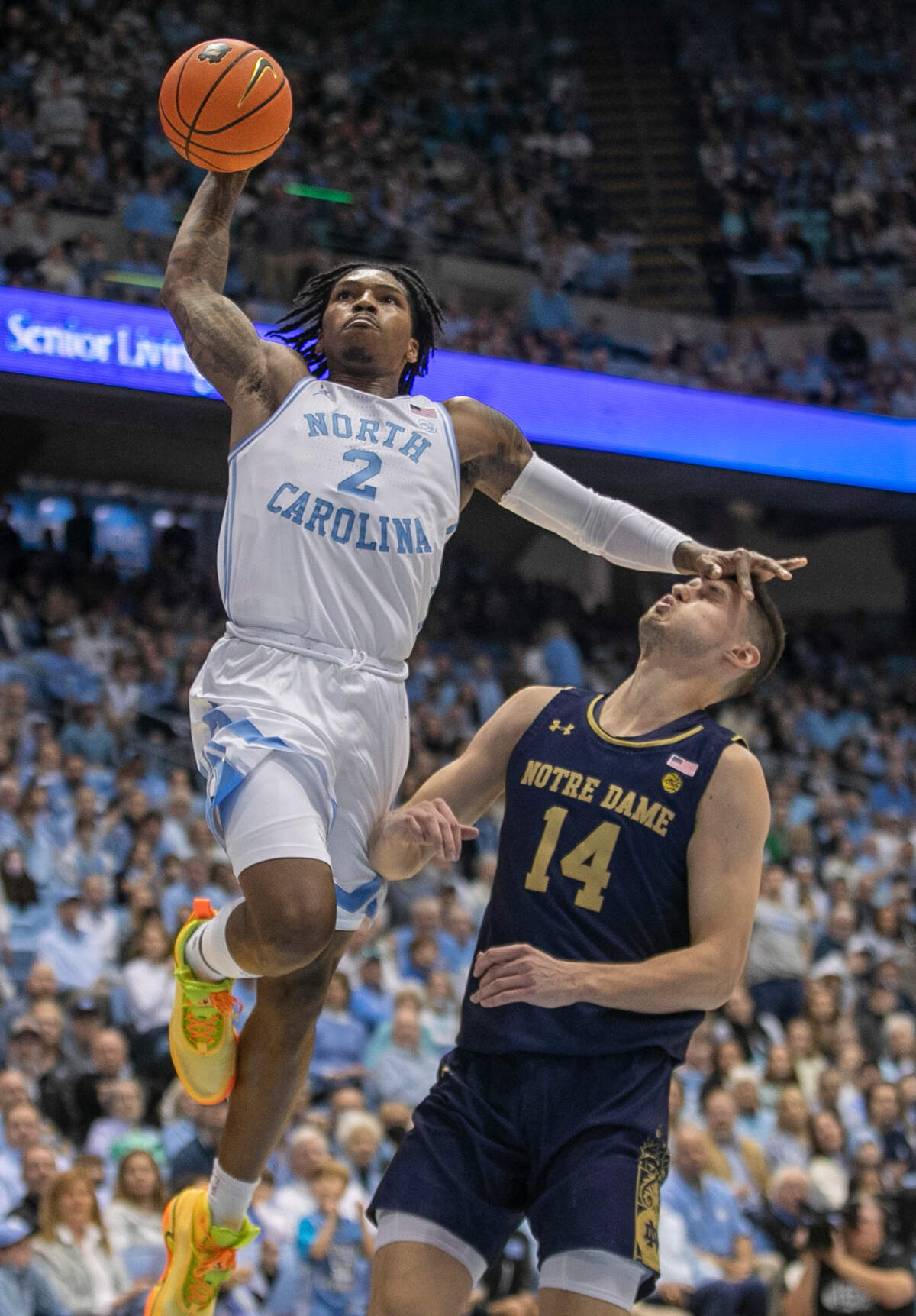 North Carolina’s Caleb Love (2) breaks to the basket for a dunk against Notre Dame’s Nate Laszewski (14) during the first half on Saturday, January 7, 2023 at the Smith Center in Chapel Hill, N.C.