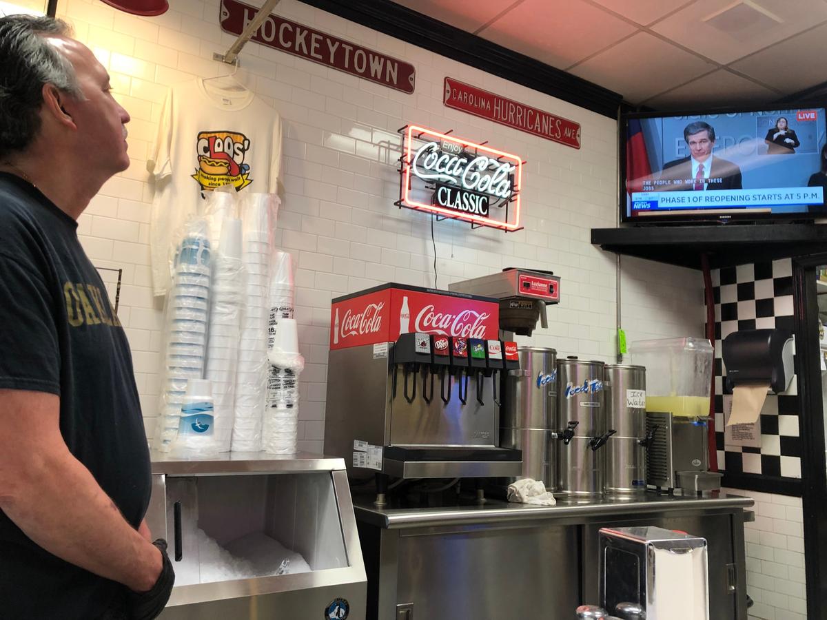 Dan Cloos watches N.C. Gov. Roy Cooper’s press conference Friday afternoon, May 8, 2020, during a lull in orders at Cloos’ Coney Island.