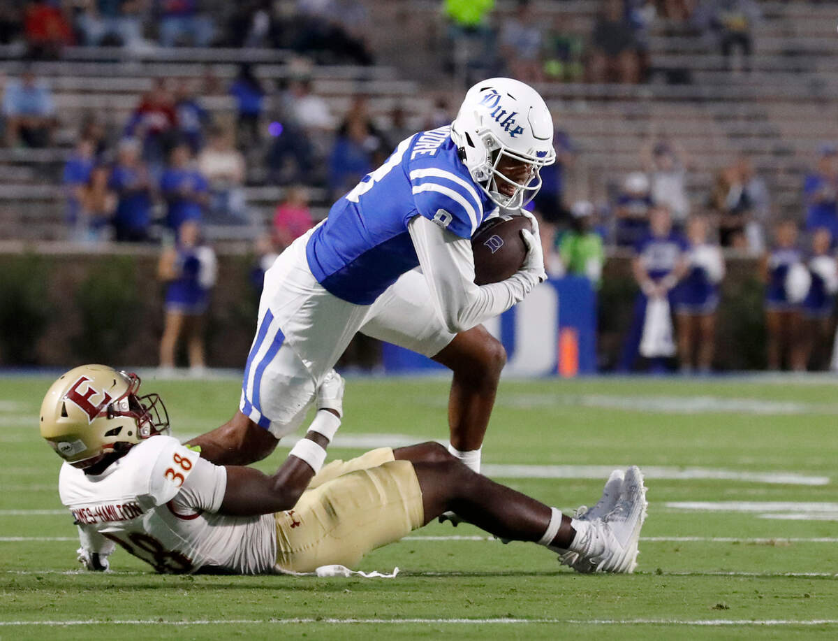 Duke’s Jordan Moore runs the ball past Elon’s DJ Hamilton during the first half of the Blue Devils’ season opener on Friday, Aug. 30, 2024, at Wallace Wade Stadium in Durham, N.C.