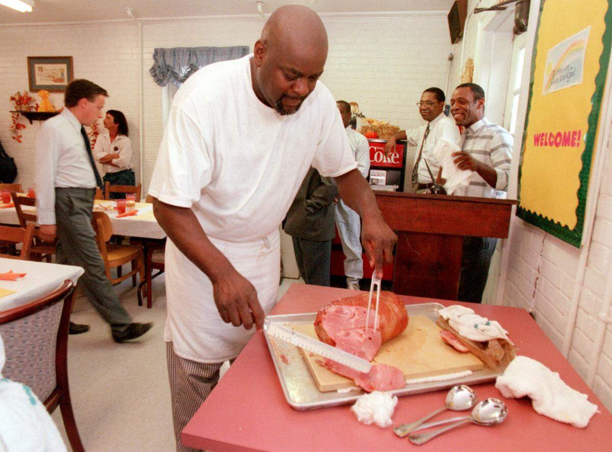 In a 1997 photo, Angus Barn chef Walter Royal carves up a ham at the Durham Rescue Mission for a donated feast.
