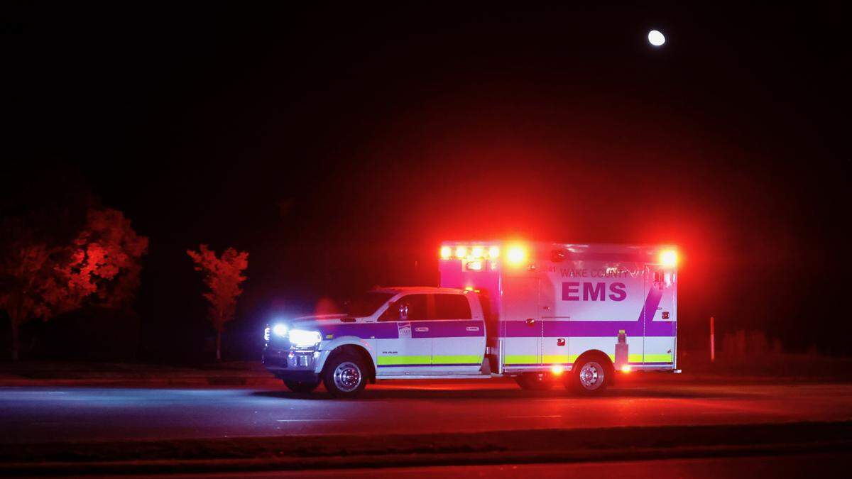 An ambulance that was escorted by two police officers on motorcycles rushes down New Bern Avenue shortly before 10 p.m. in after 5 people were shot and killed in the Hedingham Neighborhood and Nuese River Trail area in Raleigh Thursday, Oct. 13, 2022.