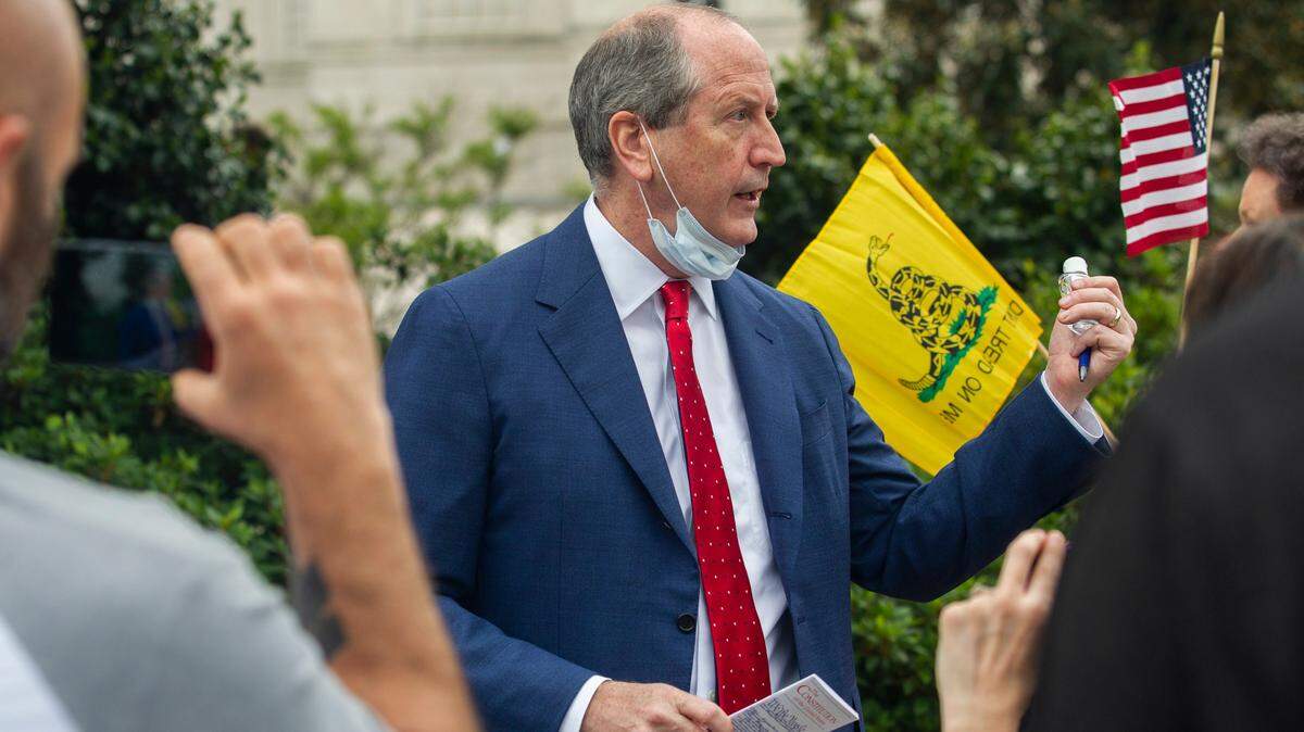U.S. Rep. Dan Bishop holds a copy of the Constitution and a bottle of hand sanitizer while talking with constituents and reporters during a ReOpen NC protest in downtown Raleigh, N.C. Tuesday, April 21, 2020.