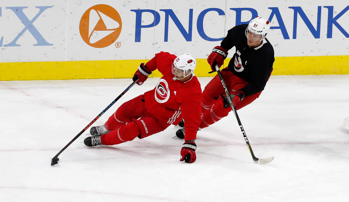 Carolina center Sebastian Aho (20) gets around Jake Gardiner (51) during the Carolina Hurricanes’ on-ice workouts at PNC Arena in Raleigh, N.C., Monday, July 13, 2020.