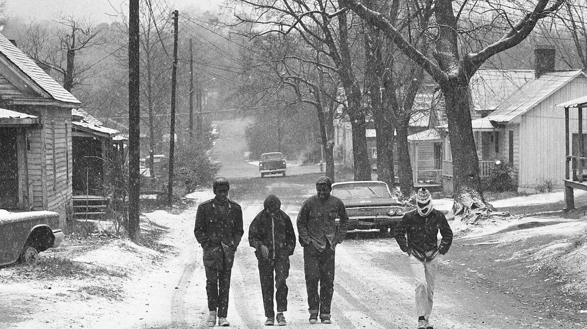 Young men walk up Cannon Avenue in the Fourth Ward neighborhood of Raleigh on a snowy day in 1971.