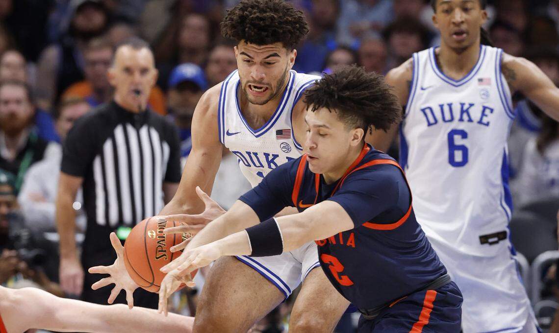 Duke’s Cameron Boozer (12) keeps the ball from Virginia's Chance Mallory (2) during the first half of Duke’s game against Virginia in the finals of the 2026 ACC Men’s Basketball Tournament at the Spectrum Center in Charlotte, N.C., Saturday, March 14, 2026.