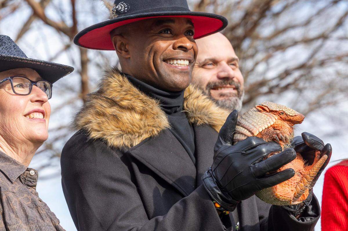 Apex Mayor Jacques Gilbert holds up an armadillo named ‘Sylvia’ after it predicted an early spring according to Gilbert on Groundhog Day, Feb. 2, 2024 at Olive Chapel Elementary School in Apex.