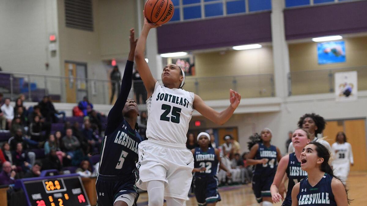 Jamia Hazell (25) of Southeast drives to the basket against Nia Young (5) and Lola Jacobs (20) of Leesville Road . The Leesville Road Pride played the Southeast Raleigh Bulldogs in a high school women basketball game on February 22, 2019.