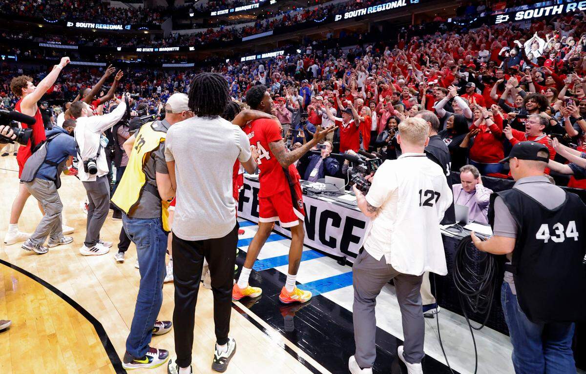 The Wolfpack celebrate with the crowd after N.C. State’s 67-58 victory over Marquette in their NCAA Tournament Sweet 16 game at the American Airlines Center in Dallas, Texas, Friday, March 29, 2024.
