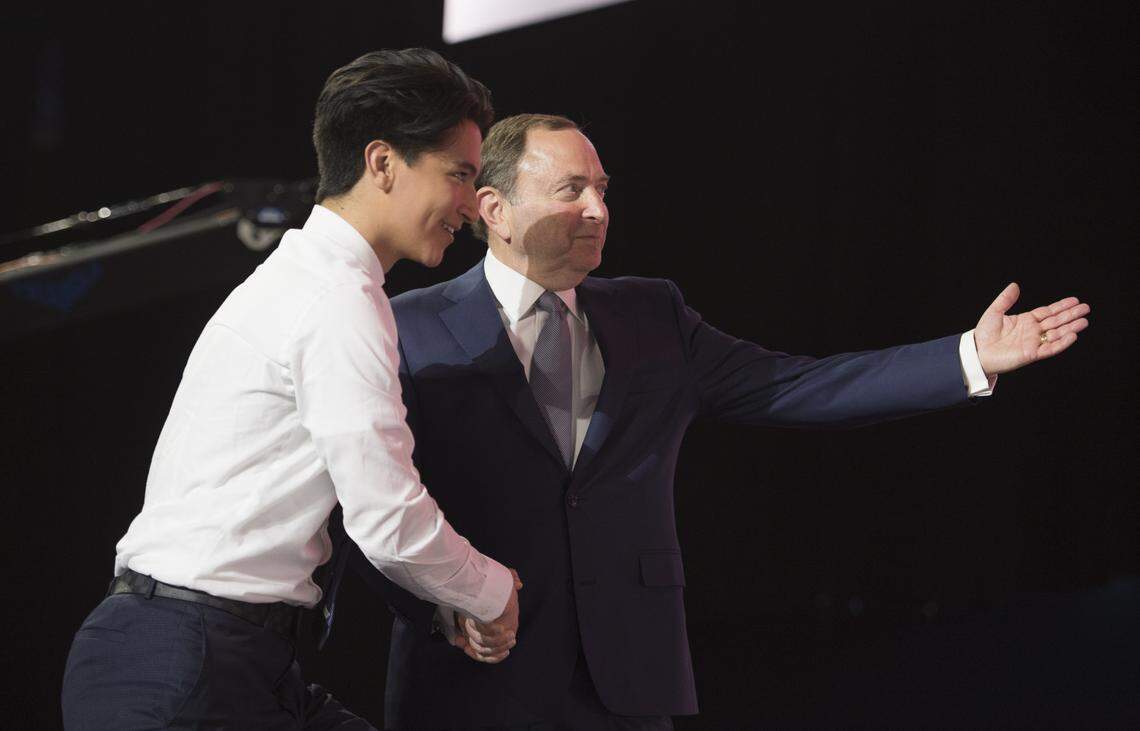 NHL Commissioner Gary Bettman, right, welcomes Carolina Hurricanes pick Ryan Suzuki during the first round of the NHL hockey draft at Rogers Arena in Vancouver, British Columbia, Friday, June, 21, 2019. (Jonathan Hayward/The Canadian Press via AP)