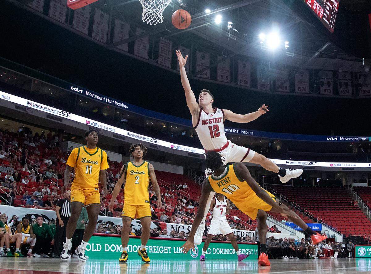 N.C. State’s Michael O’Connell draws a charge against Lees-McRaes’ DJ Kent during the first half of the Wolfpack’s 79-75 exhibition win on Wednesday, Oct. 30, 2024, at the Lenovo Center.