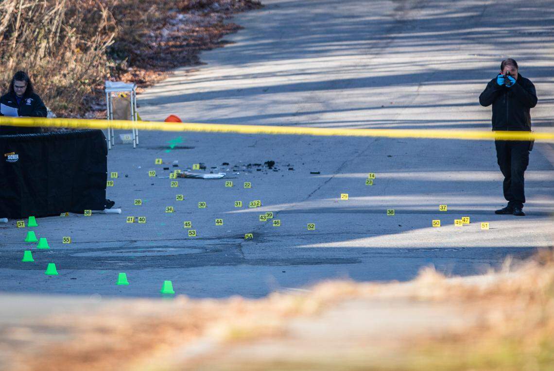 Forensic investigators work at the scene of a shooting that killed two young people and injured four others in Durham, N.C. early on Monday morning, Dec. 13, 2021.