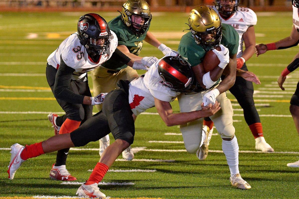 Cardinal Gibbons’ Blake Raphael (5) runs for the touchdown against Rolesville’s Jaccorey Bible (11) during the third quarter. The Cardinal Gibbons Crusaders and the Rolesville Rams met in the NCHSAA 4A East Regional Final in Raleigh, N.C. on December 3, 2021