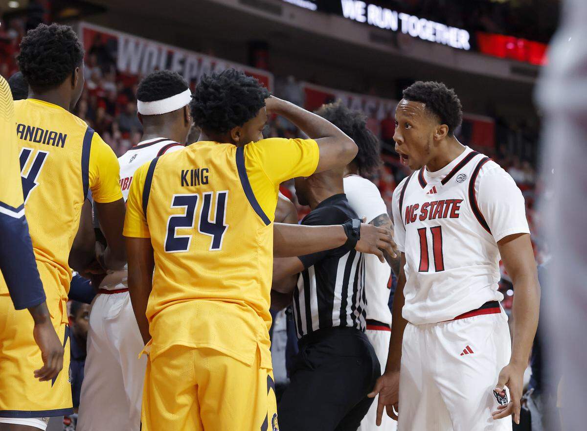 N.C. State’s Quadir Copeland has words with UNC Greensboro’s Landon King during the first half of the Wolfpack’s game on Wednesday, Nov. 12, 2025, at Lenovo Center in Raleigh, N.C.