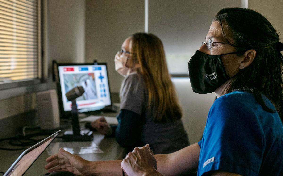 Wake Technical Community College instructor Kim Clarke, right, and clinical instructor Rebecca Peckey monitor students from a control room adjacent to a hospital room setting on Friday, Oct. 1, 2021, at the Perry Health Sciences Campus in Raleigh, N.C.