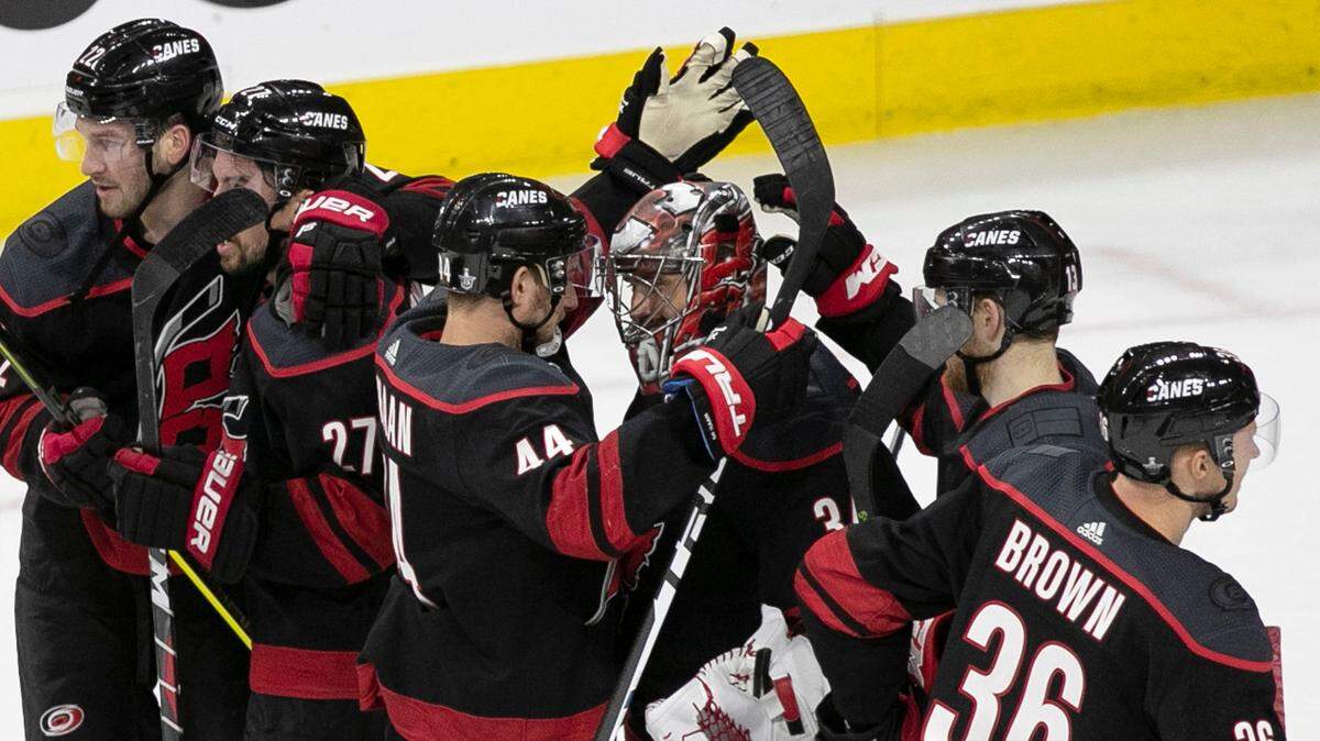Carolina Hurricanes goalie Petr Mrazek (34) is surrounded by his teammate as they celebrate their 2-1 victory over the Washington Capitals in game four of the first round Stanley Cup series game on Thursday, April 18, 2019 at the PNC Arena in Raleigh, N.C.