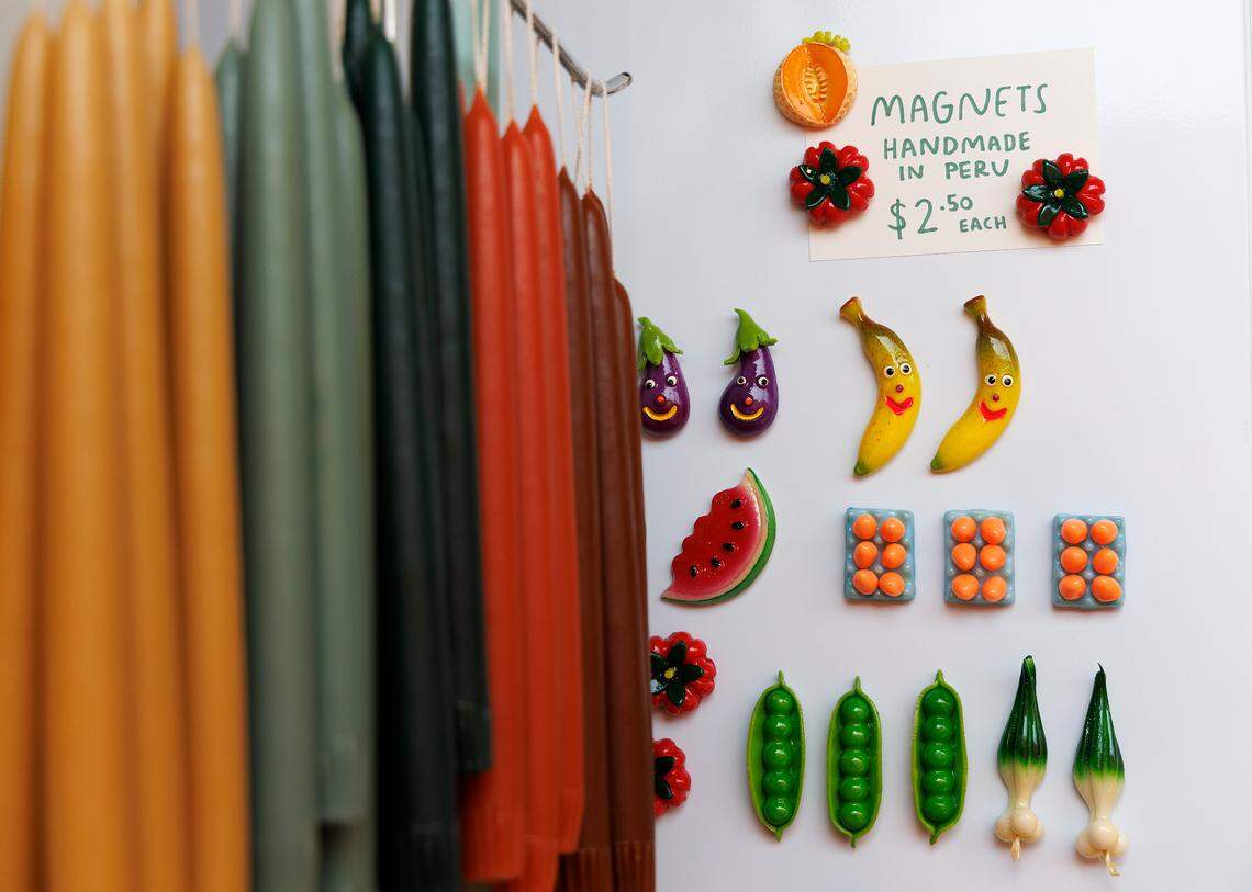 A selection of taper candles and magnets are photographed in the retail market at Redstart Takeaway on Wednesday, Aug. 28, 2024, in Durham, N.C.