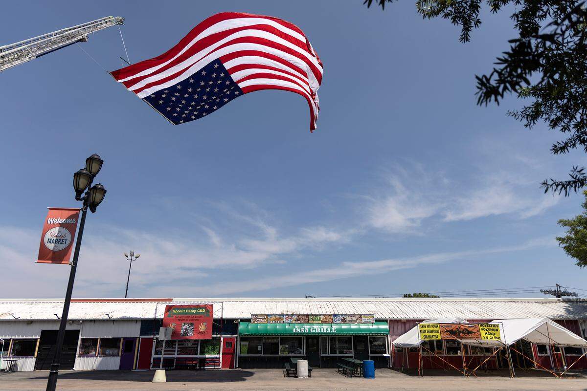 An American flag flies above the North Carolina State Fairgrounds prior to a memorial service for K9 Santos, a Wake County sheriff’s dog, at the Kerr Scott Building on Wednesday, June 14, 2023, in Raleigh, N.C. K9 Santos, a German shepherd, was accidentally shot and killed by a Knightdale police officer after a traffic stop in May.