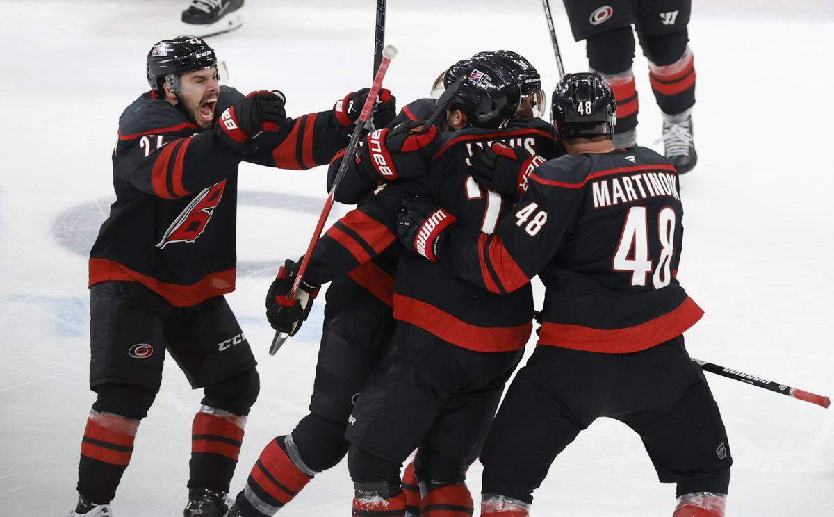 Players mob Carolina's Seth Jarvis (24) after he scored in overtime of the Hurricanes’ 4-3 victory over the Golden Knights in the second game of the Stanley Cup Final at the Lenovo Center in Raleigh, N.C., Thursday, June 4, 2026.