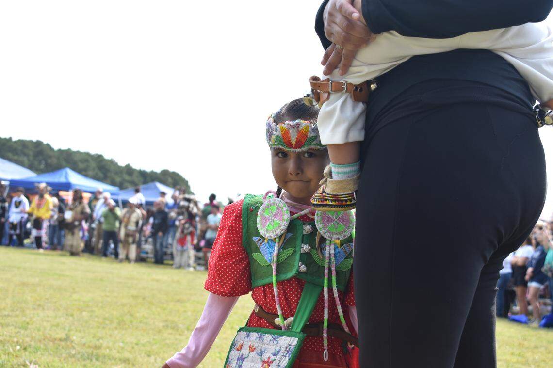 Young dancer hides behind her mother’s leg at the Dix Park Pow Wow.