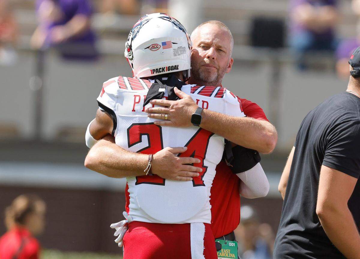 N.C. State head coach Dave Doeren hugs Derrek Pitts Jr. (24) before N.C. States game against ECU at Dowdy-Ficklen Stadium in Greenville, N.C., Saturday, Sept. 3, 2022.