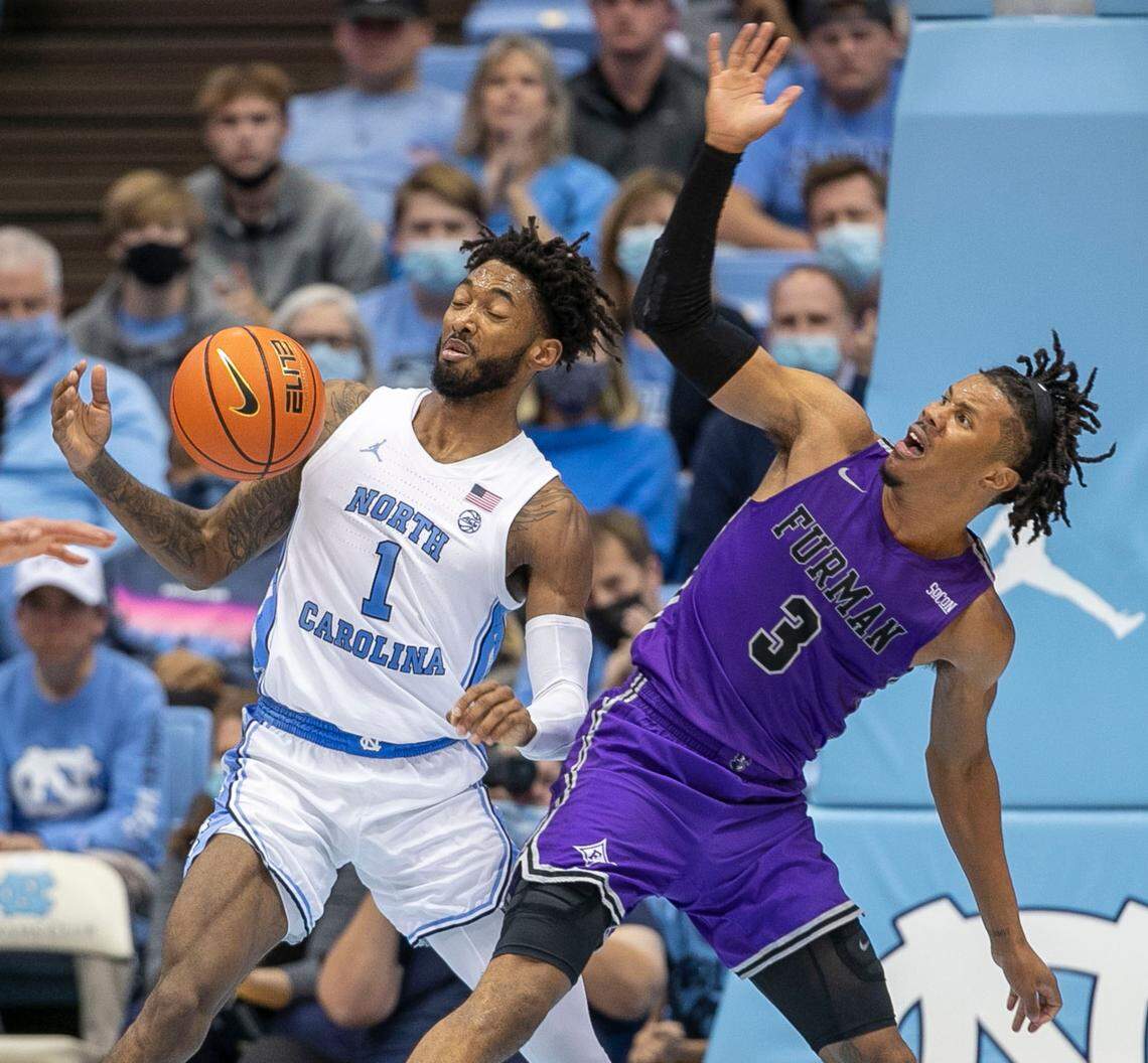 North Carolina’s Leaky Black (1) and Furman’s Mike Bothwell (3) battle for a loose ball during the second half on Tuesday, December 14, 2021 at the Smith Center in Chapel Hill, N.C.
