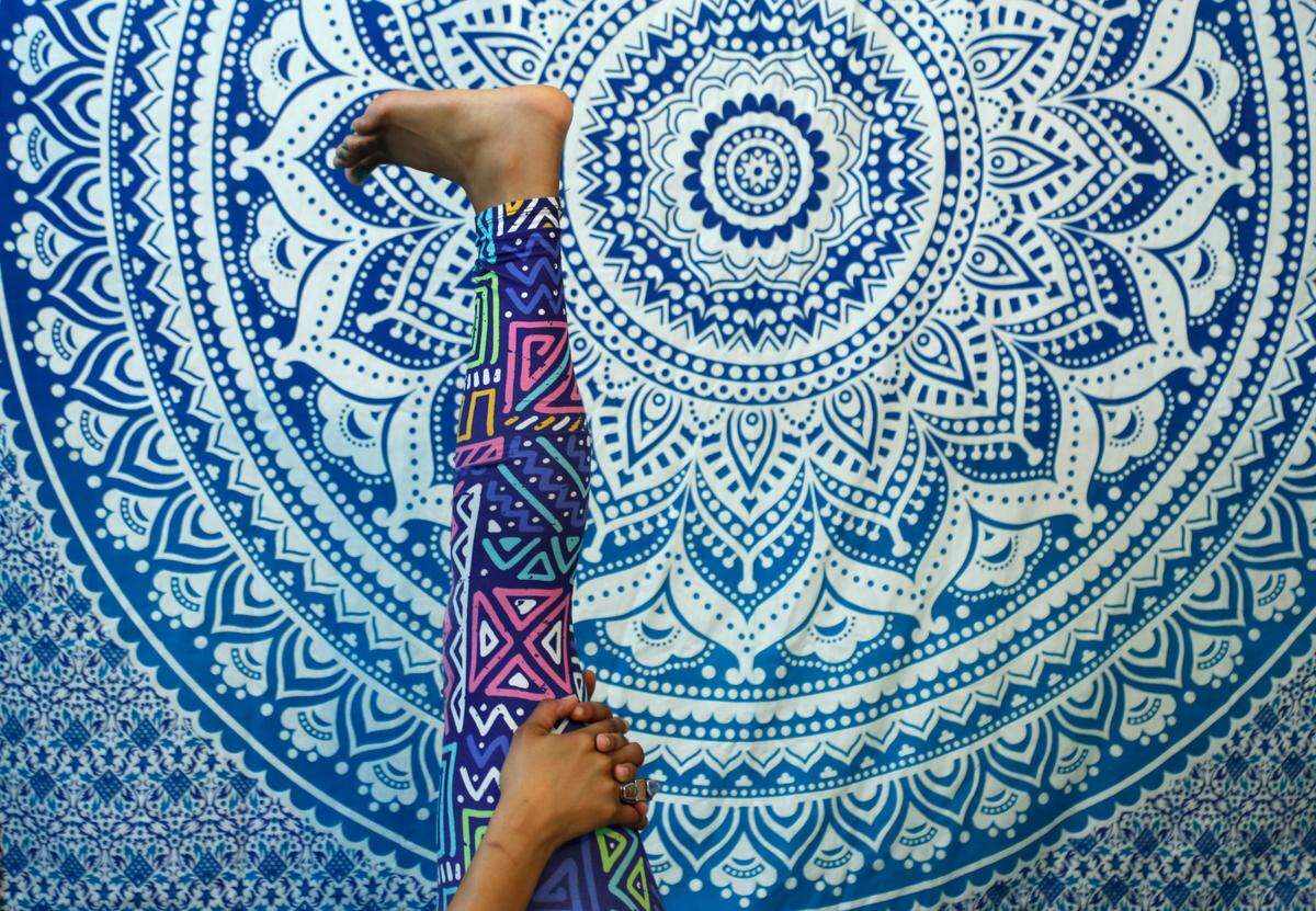 Patrice Graham, owner of Colors of Yoga Raleigh, leads a virtual yoga class using Zoom in her home Wednesday, March 25, 2020. Zoom allows Graham to interact and connect with her students.