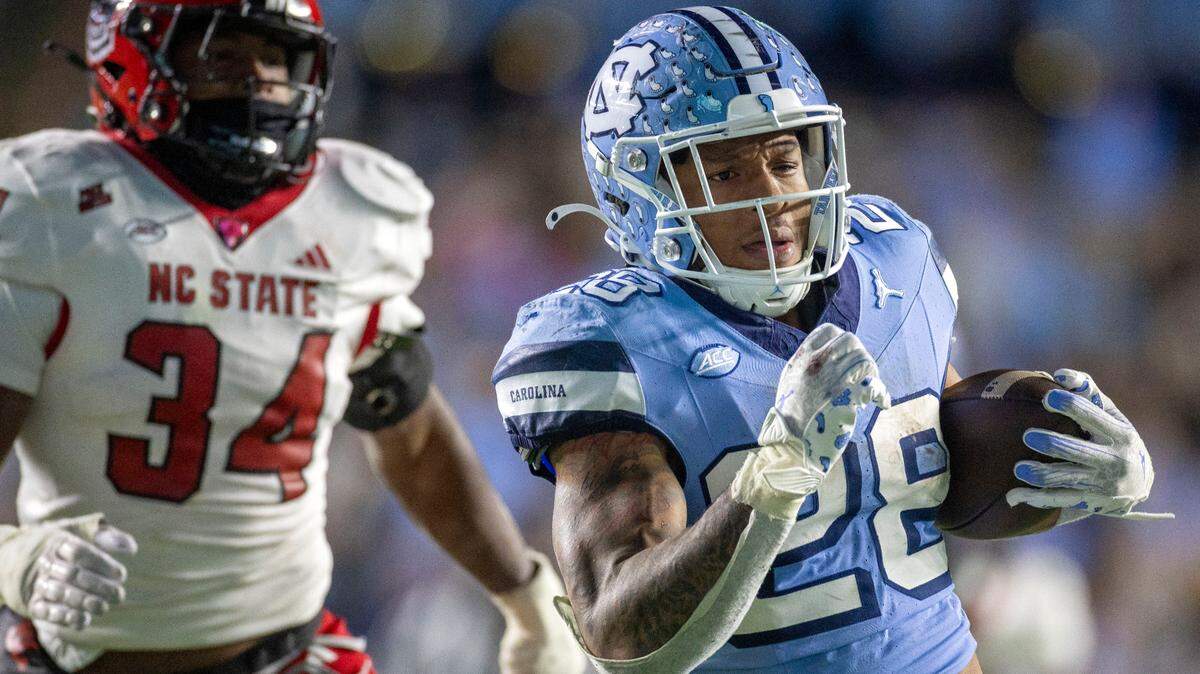 North Carolina running back Omarion Hampton (28) scores a touchdown ahead of N.C.State linebacker Kamal Bonner (34) on a 47-yard pass reception from quarterback Jacolby Criswell in the fourth quarter on Saturday, November 30, 2024 at Kenan Stadium in Chapel Hill, N.C.