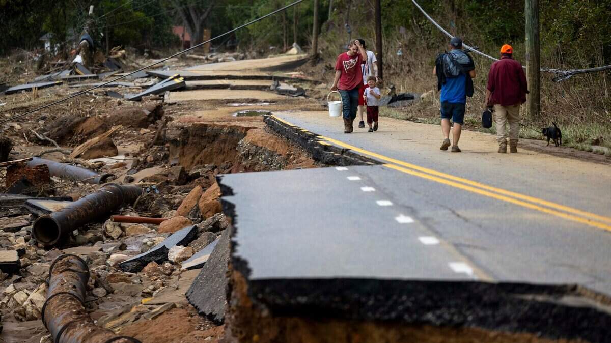 Swannanoa residents walk through devastating flood damage from the Swannanoa River on Sunday, Sept. 29, 2024. The remnants of Hurricane Helene caused widespread flooding, downed trees, and power outages in western North Carolina.