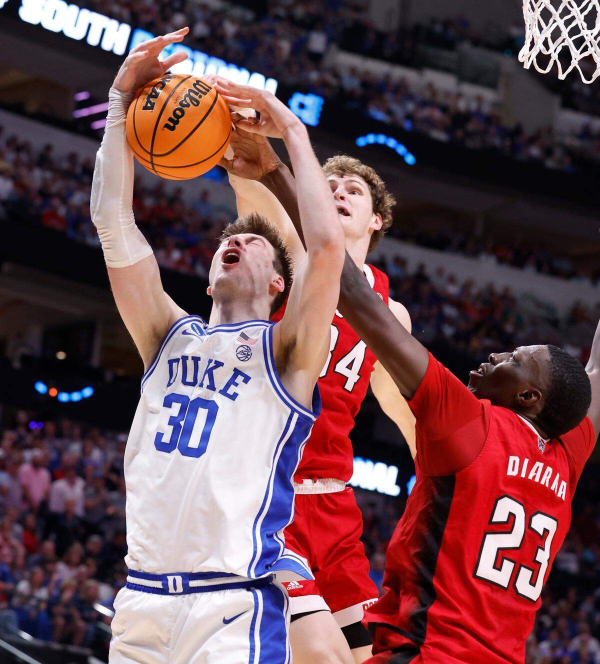 N.C. State’s Ben Middlebrooks (34) blocks the shot by Duke’s Kyle Filipowski (30) as N.C. State’s Mohamed Diarra (23) also defends during the first half of N.C. State’s game against Duke in their NCAA Tournament Elite Eight matchup at the American Airlines Center in Dallas, Texas, Sunday, March 31, 2024.
