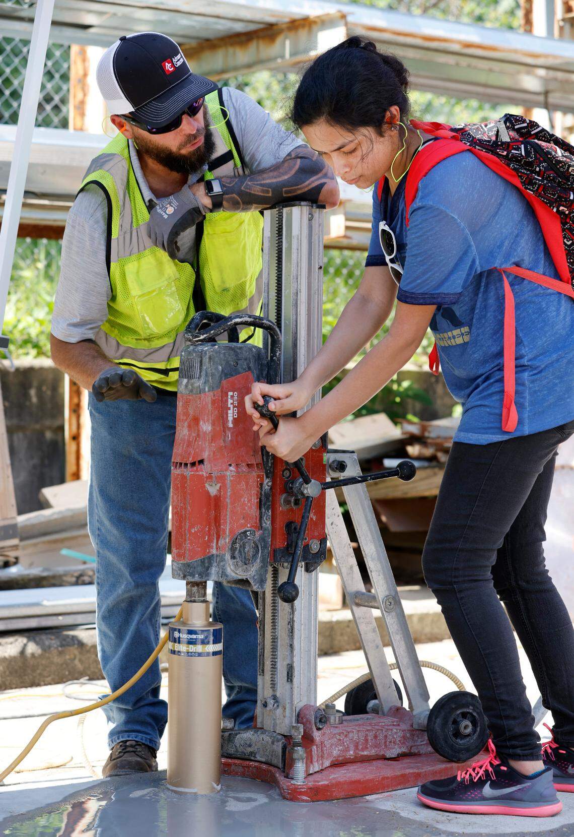 Billy Summerlin with Advance Concrete instructs Arwen Banerjee, a rising senior at Panther Creek High School, how to cut concrete during Construction Field Day at Bobbitt Design Build in Raleigh, N.C., Tuesday, July 19, 2022.