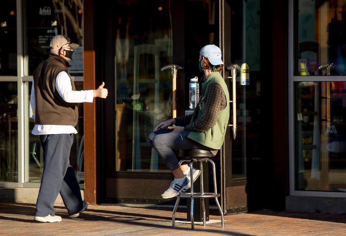 “Most everybody is very good about it,” said Ben Campbell, right, a sales specialist at REI in Durham, while stationed outside the entrance greeting customers and denying entry to any who refuse to wear a mask on Tuesday, Dec. 8, 2020.