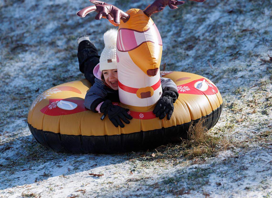 Isabella McCall, 7, smiles while sledding down a hill at Bond Park on Wednesday, Jan. 22, 2025, in Cary, N.C.