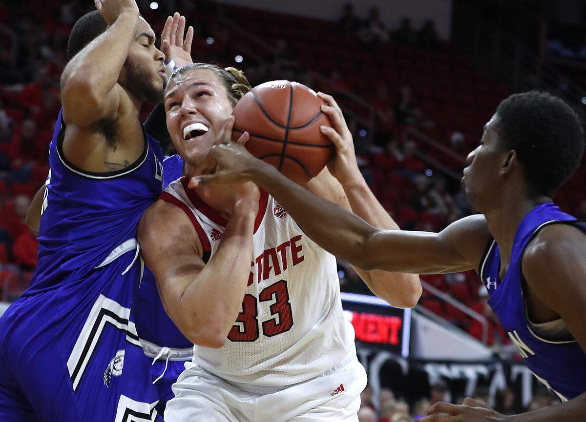 N.C. State’s Wyatt Walker (33) keeps the ball from Chowan’s Trejvon McFail, left, and Gus Rowland (11) during the second half of N.C. State’s 111-62 exhibition victory over Chowan at PNC Arena in Raleigh, N.C., Monday, Oct. 29, 2018.