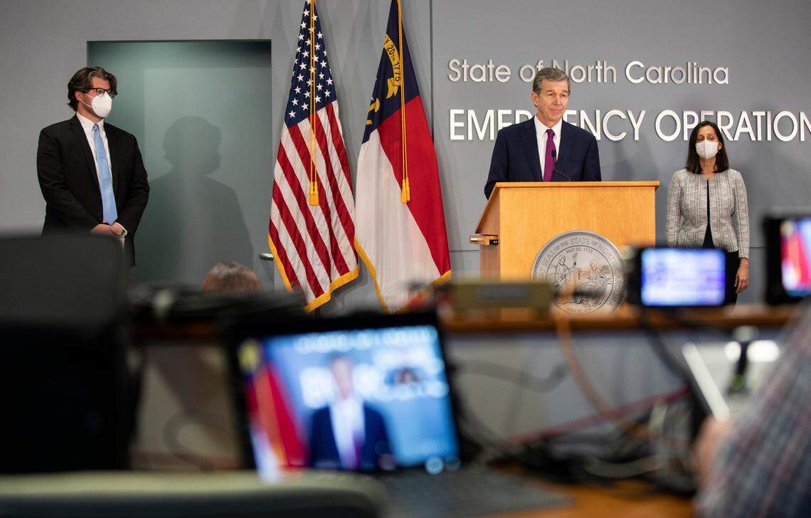 N.C. DHHS Secretary Kody Kinsley, left, Governor Roy Cooper, middle, and Dr. Susan Kansagra, right, hold a press conference in Raleigh, N.C. to talk about the state of the COVID-19 pandemic on Tuesday, Jan. 4, 2022.