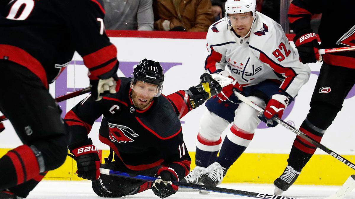 Carolina Hurricanes’ Jordan Staal (11) falls to the ice after being tripped by Washington Capitals’ Evgeny Kuznetsov (92) during the first period of an NHL hockey game in Raleigh, N.C., Sunday, Nov. 28, 2021. (AP Photo/Karl B DeBlaker)